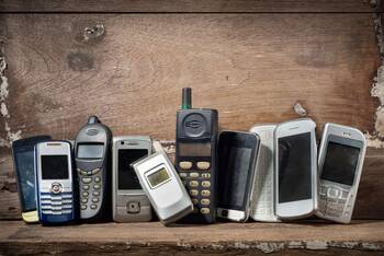 Alte Mobiltelefone an Holzwand gelehnt