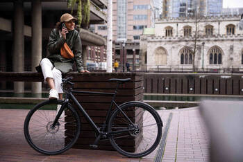 Frau posiert neben Fahrrad