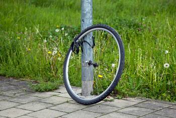 Ein Fahrradreifen ist an einer Laterne mit einer Fahrradkette angeschlossen.