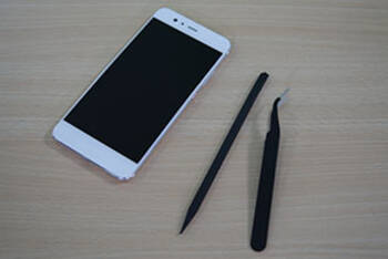 Weißes Smartphone liegt neben Handy-Werkzeug 