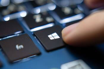Nahaufnahme von Windows Tastatur mit Finger, der auf Windows-Symbol zeigt