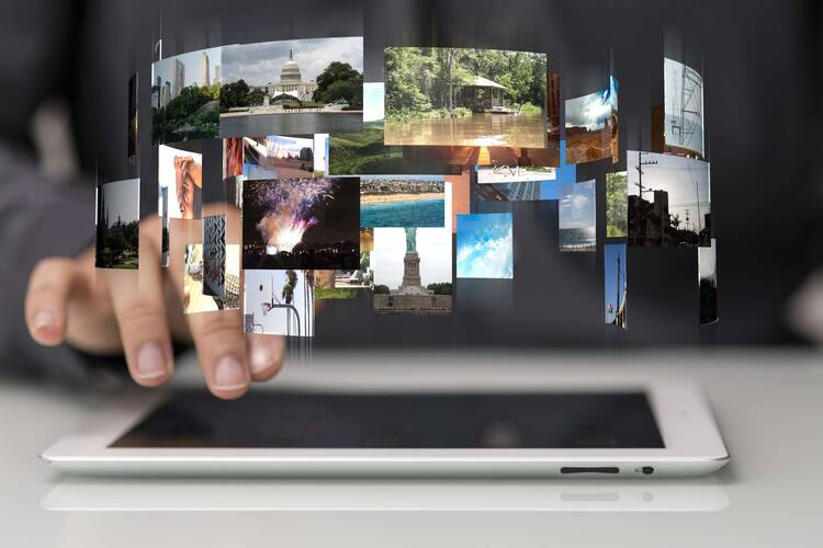 Über Tablet schwebt eine virtuelle Wolke aus Fotos