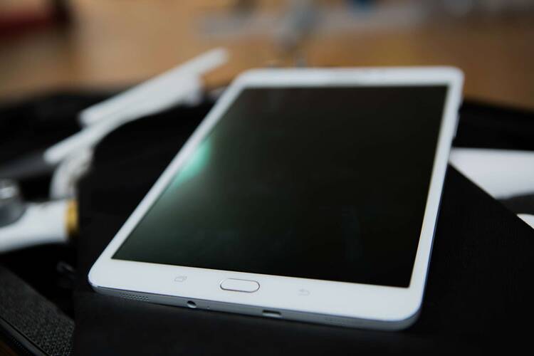Weißes Samsung Tablet liegt auf neutralem, arbeitsplatzähnlichem Untergrund