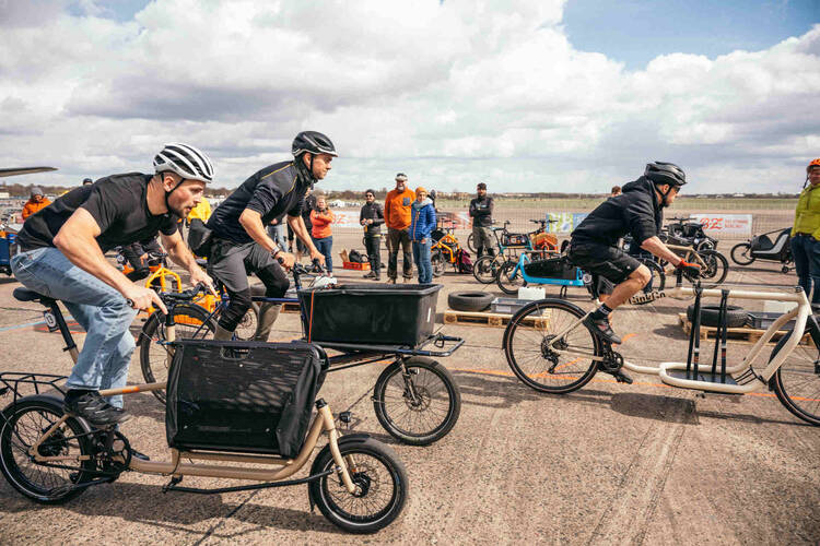 Personen fahren auf der Velo Berlin ein Wettrennen mit Lastenfahrrädern