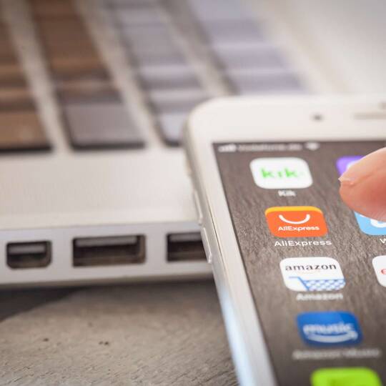 Finger zeigt auf App-Icon auf iPhone Homescreen