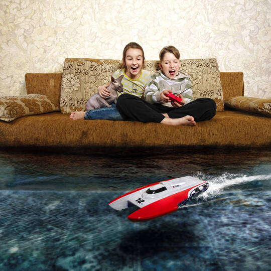 Kinder spielen mit RC Boot im Wohnzimmer