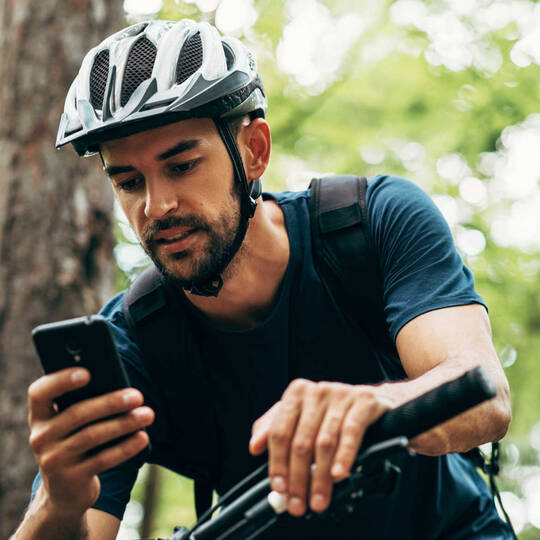 Fahrradfahrer bedient sein Handy