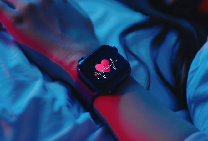 Eine Person trägt eine Apple Watch, auf der ein Herz-Symbol zu sehen ist, während sie schläft.