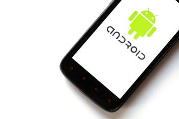 Ein schwarzes Handy mit Android Logo liegt auf einem weißen Hintergrund