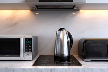 Ein Wasserkocher steht auf dem Herd in einer Küche.