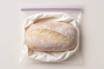 Ein Brotlaib liegt auf einem Gefrierbeutel. 
