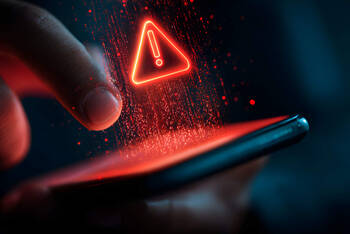 Auf einem Smartphone ist ein rotes Warndreieck zu sehen.