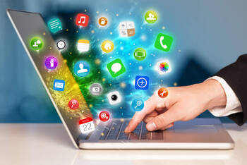 Über der Tastatur eines Laptops schweben mehrere Icons von unterschiedlichen Programme und Apps.