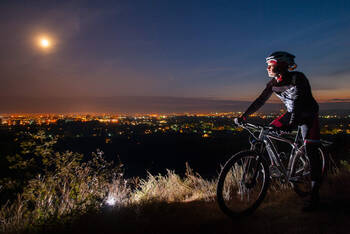 Ein Fahrradfahrer beobachtet den Mond im Dunkeln