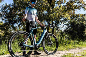 Mann steht neben futuristischem E-Bike