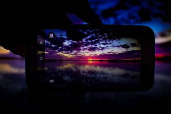 Sonnenuntergang auf Smartphonedisplay durch Kamera
