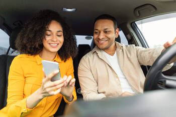 Paar benutzt Smartphone im Auto