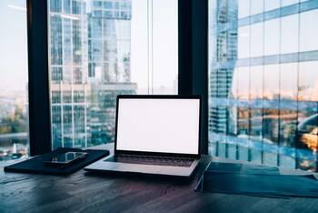 Arbeitsplatz mit MacBook vor Hochhäuser-Aussicht