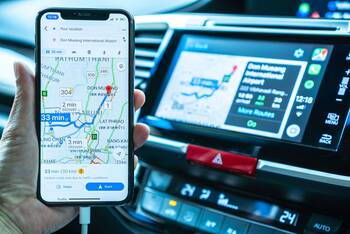 eine Person nutzt Google Maps mit dem Smartphone in einem Auto