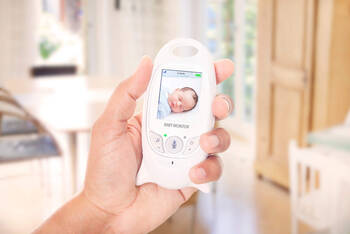 Babyphone in der Hand überwacht das Baby