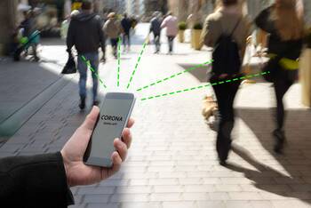 Smartphone in Fußgängerzone mit grünen gestrichelten Linien, die den Abstand zu Passanten darstellen sollen