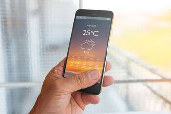 Smartphone mit geöffneter Wetter App auf der Bildschirmanzeige