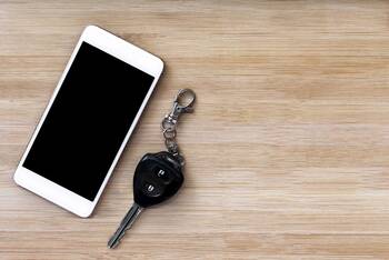 Smartphone und Autoschlüssel liegen nebeneinander