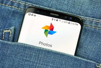 ein Smartphone steckt in der Hosentasche und zeigt dei Google Fotos App