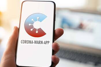 Hand hält Smartphone mit Corona App