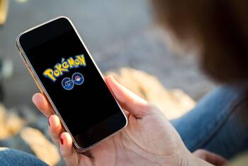 Person hält Smartphone in der Hand, auf welchem Pokémon-Go startet