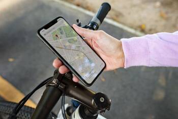 Ein Smartphone wird am Lenrad eines Fahrrads befestigt. 