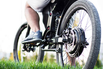 Nahabbildung von Kette und Motor eines E-Bikes.