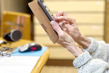 Ältere Frau hält Handy in der Hand