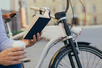 Mann auf einer Bank liest ein Buch