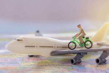Ein Spielzeug-Fahrrad fährt auf dem Tragflügel eines Spielzeug-Flugzeugs.