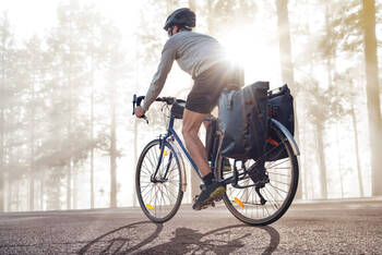 Fahrradfahrer fährt mit seiner Fahrradtasche im Wald