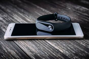 Fitness-Tracker liegt auf einem Smartphone