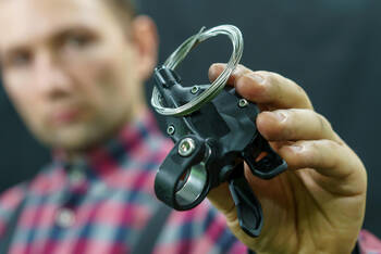 Mann hält Teil einer Fahrradschaltung in der Hand