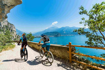 2 Fahrradfahrer fahren einen Weg am Gardasee entlang