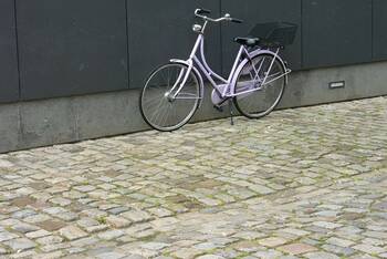 Das Hollandrad steht draußen vor einer Wand.