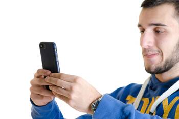 ein Mann im blauen Pullover hält sein Smartphone auf Augenhöhe vor sich
