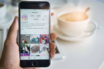 Smartphone wird in der Hand gehalten mit geöffneter Instagram App
