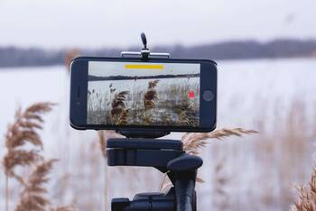 Laufende Videoaufnahme von einem Seeufer auf einem iPhone auf Stativ