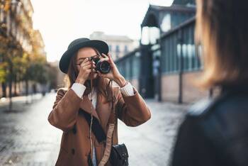 Frau fotografiert jemaden mit einer Digital-Kamera