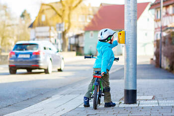 Kind auf Weg zur Schule hält an Ampel