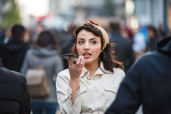 Frau spricht auf belebter Straße in Smartphone