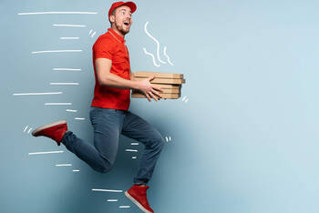 Mann springt mit Pizzakartons in die Luft