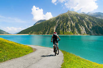 Fahrradfahrer fährt entlang der Alpen