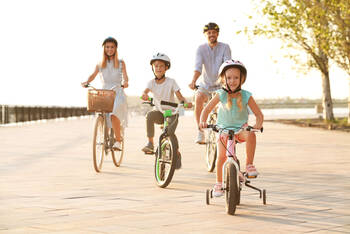Eltern fahren mit ihren Kindern Fahrrad