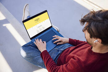 Ein Mann rtuft eine Website auf einem Laptop auf.
